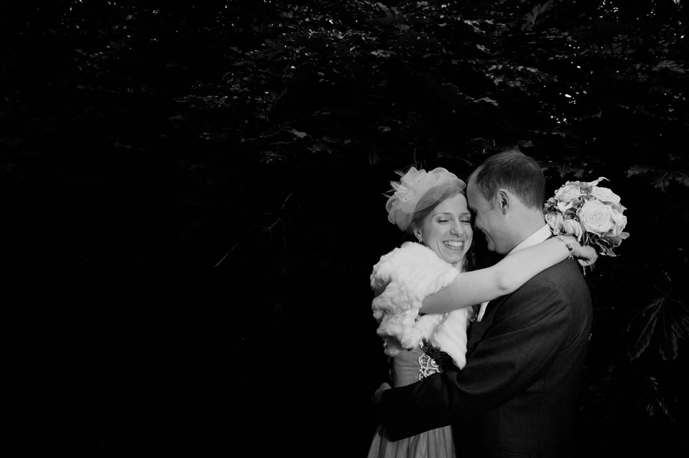 Bride and groom hugging in park