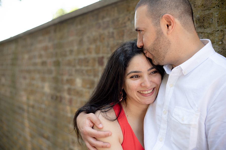 Couple hugging by wall