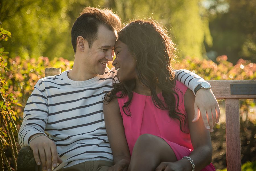 Couple looking at each other while sat on bench