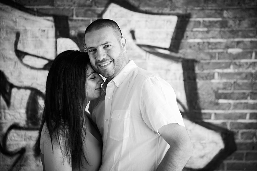 Couple stood in front of graffitied wall