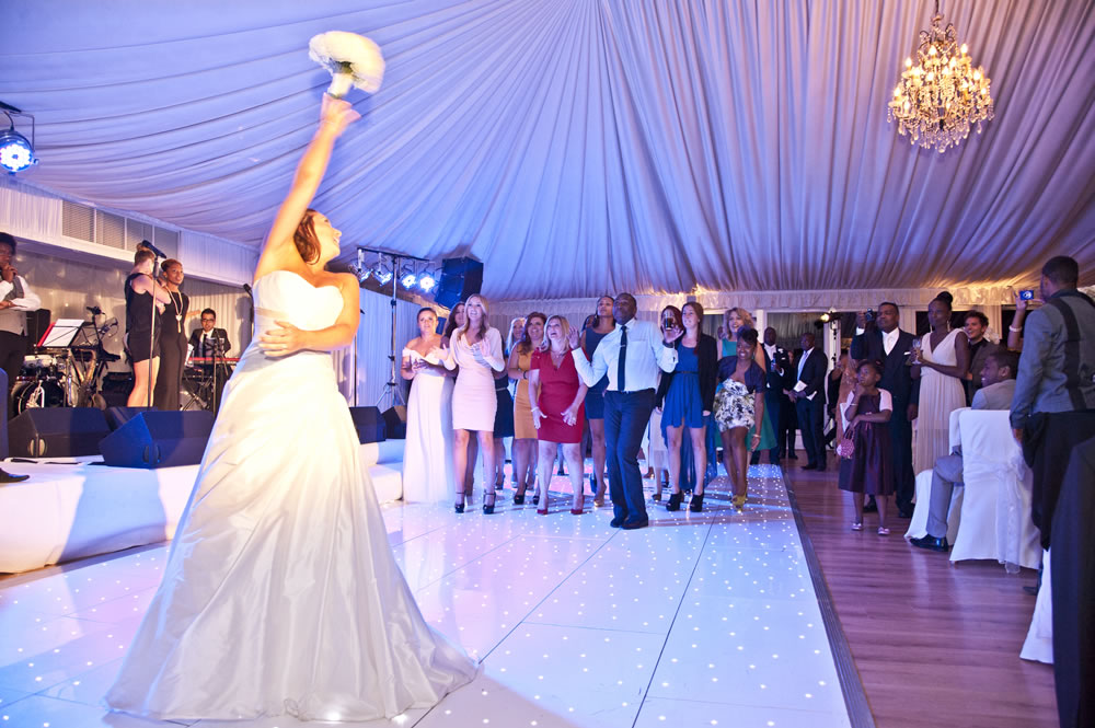 Bride tossing bouquet on dance floor