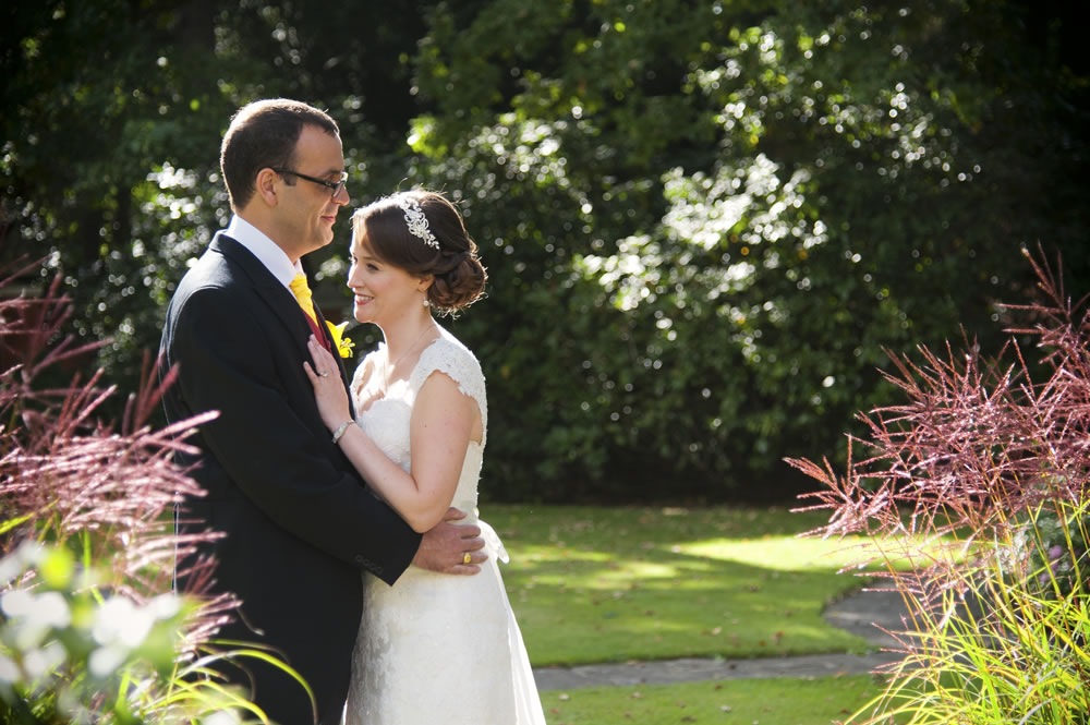 Newlyweds hugging in gardens after their wedding