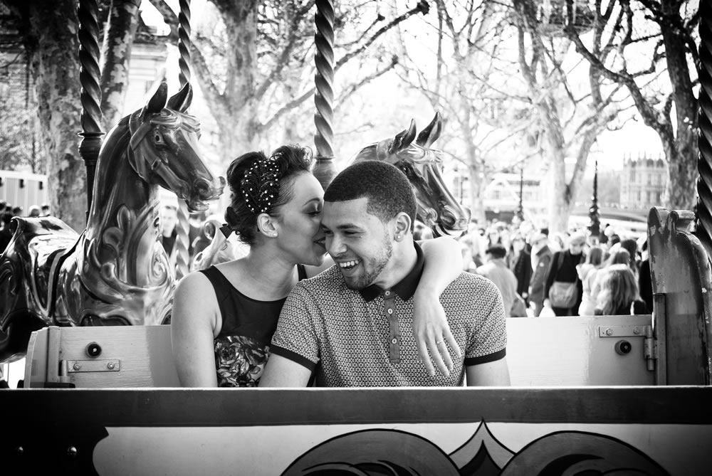 Couple sitting and laughing on carousel