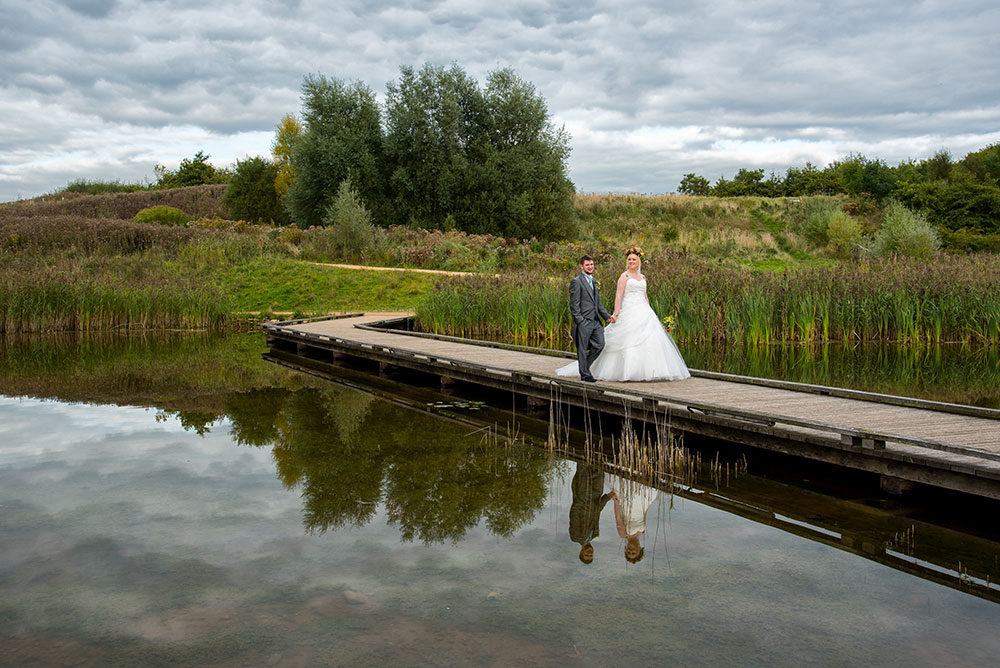 Bride and groom walking along the jetty