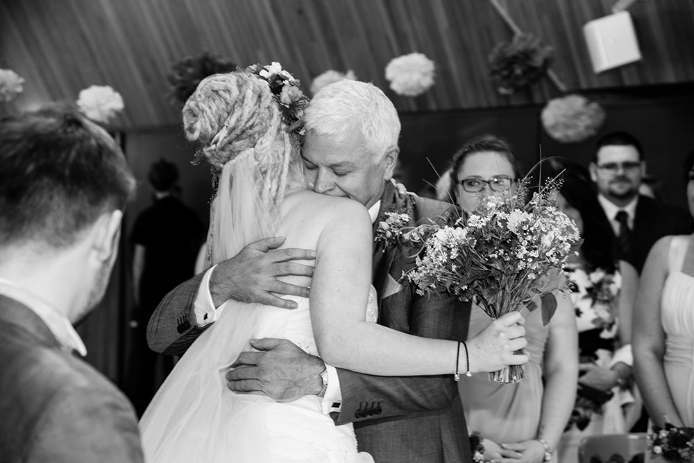 Bride and father hugging at the altar