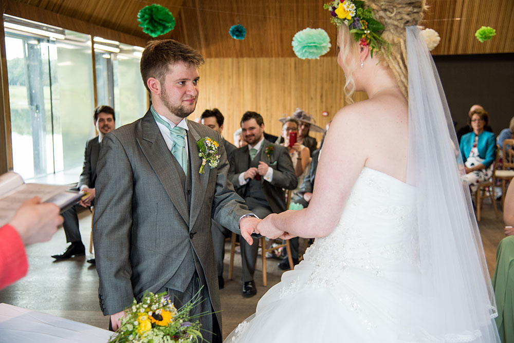 Bride putting ring on the groom