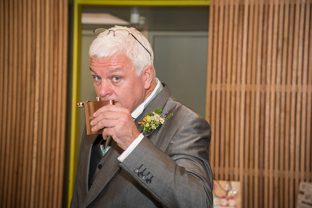 Father of bride with his hip flask before the ceremony