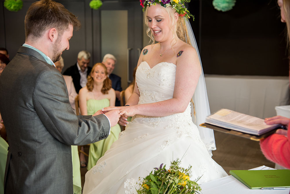 Groom putting ring on the bride