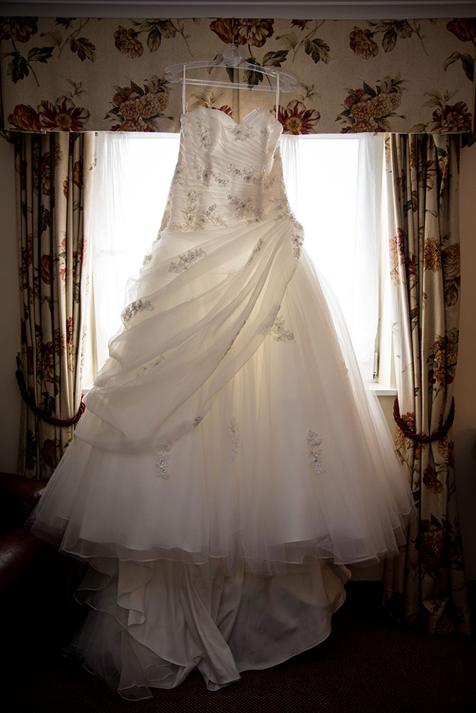 Wedding dress hanging on curtain rail