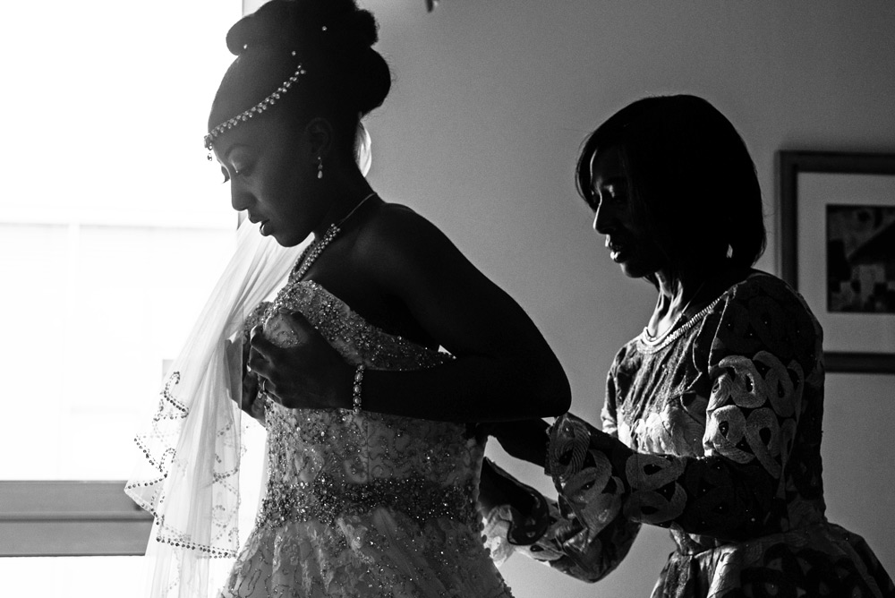 Bride getting into her wedding dress with her mum&rsquo;s help