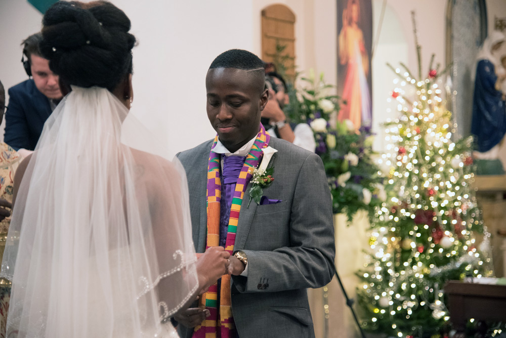 Bride putting ring on groom&rsquo;s finger