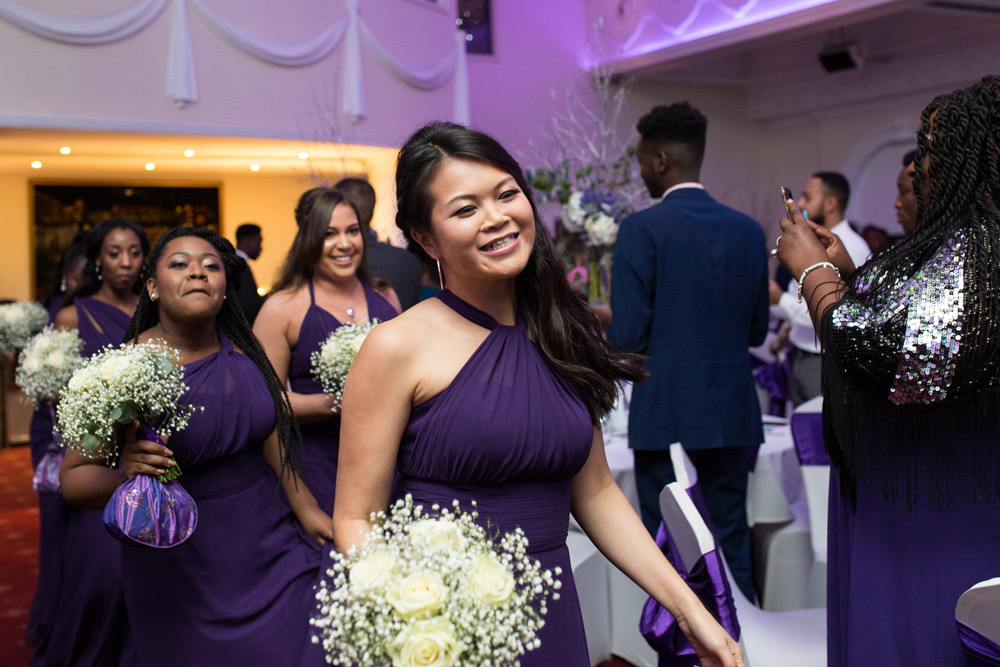 Bridesmaids dancing into reception room