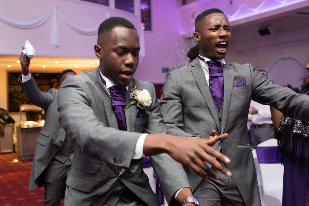 Groomsmen dancing into reception room