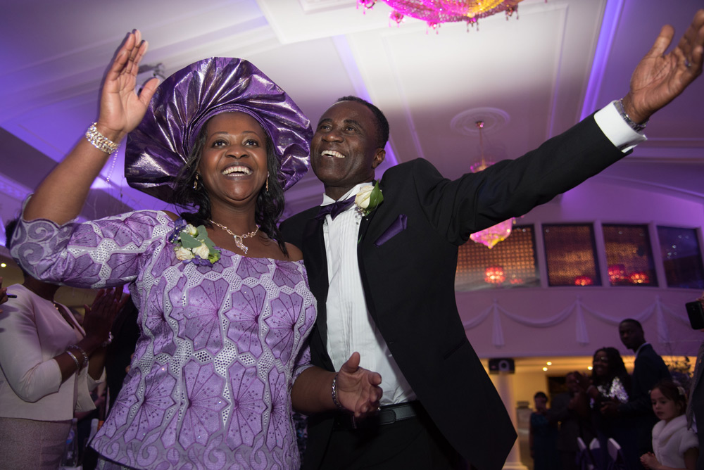 Groom&rsquo;s parents dancing into reception room