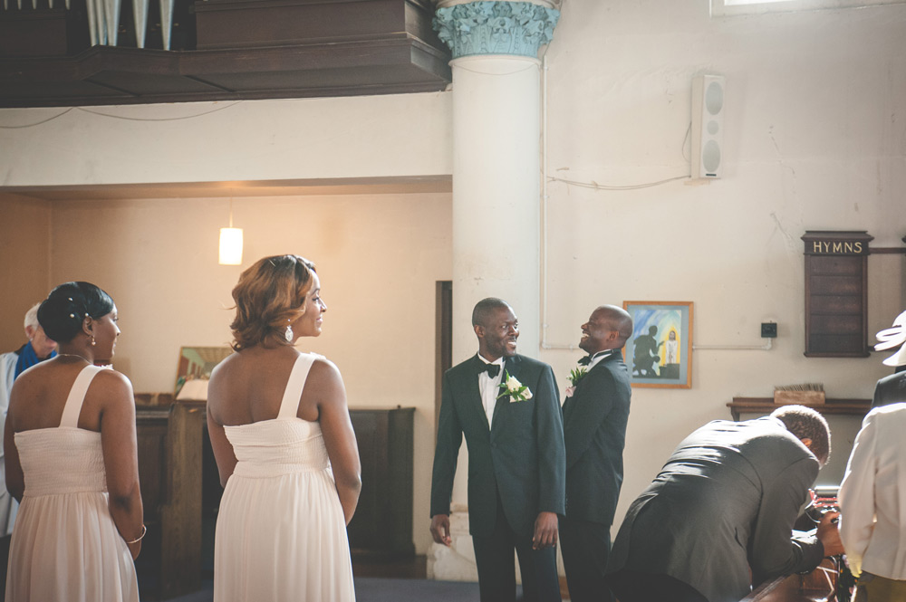 Groom looking down the aisle to watch bride arrive
