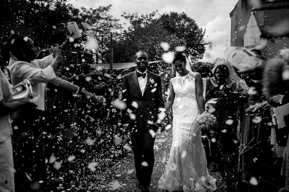 Couple walking through shower of confetti