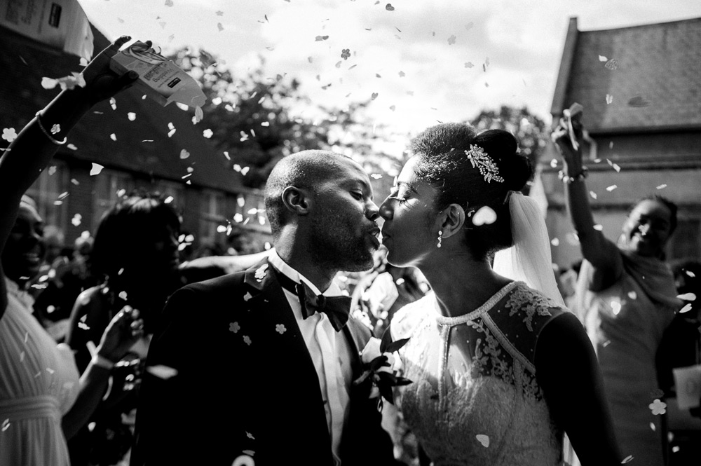 Couple kissing while being covered in confetti