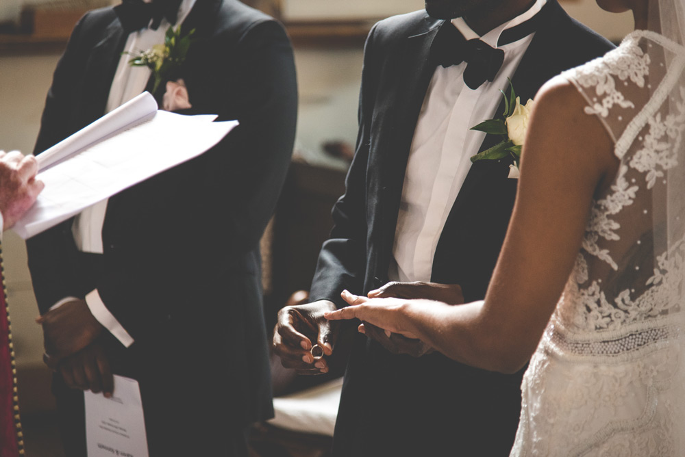 Groom holding ring before putting it on bride