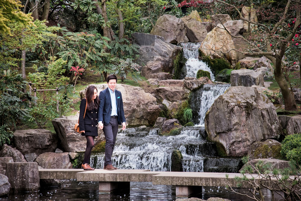 Couple walking over bridge in Japanese garden