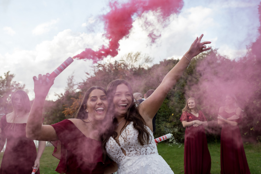 Bride and bridesmaid with smoke flares