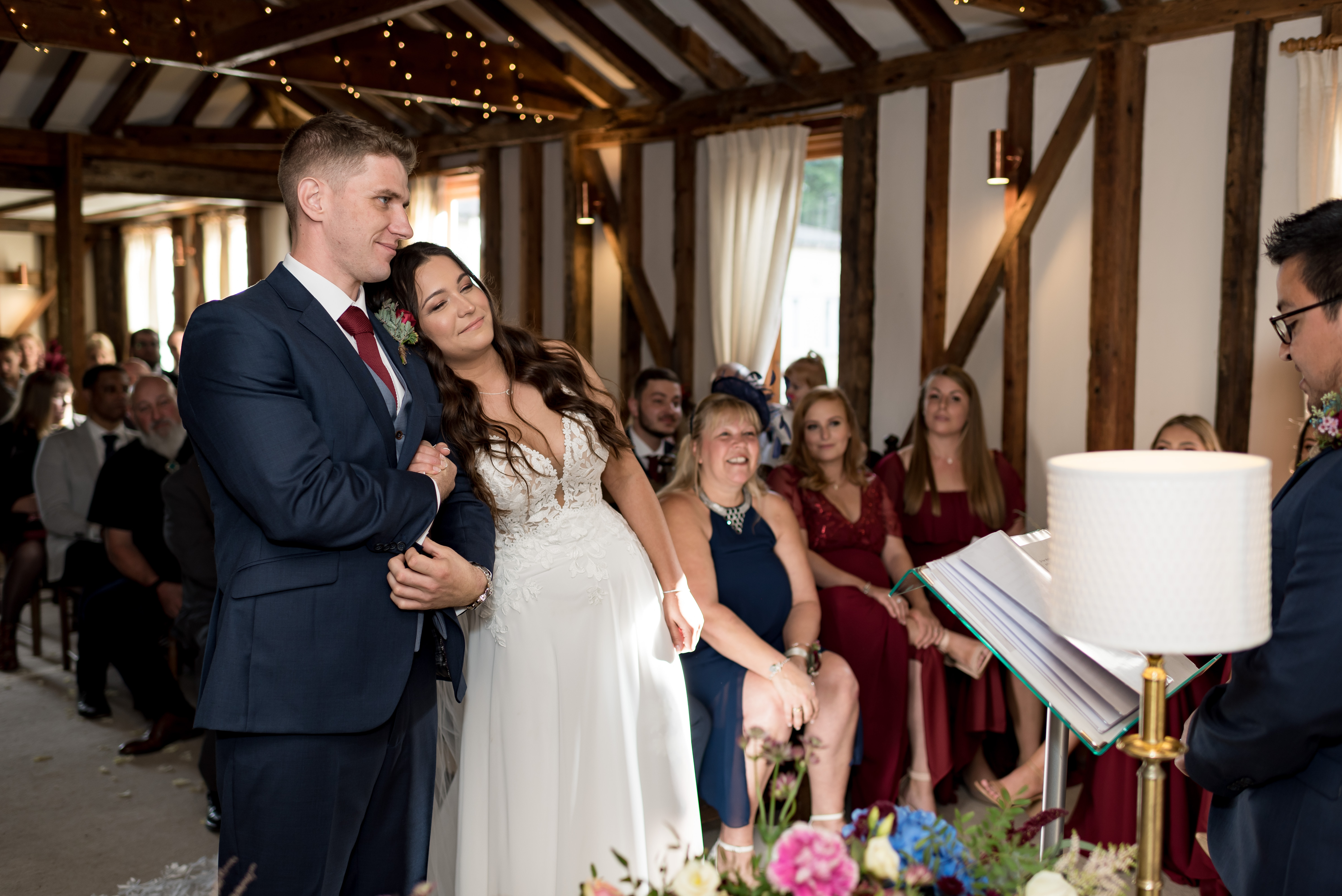 Bride leaning on groom&rsquo;s shoulder during wedding ceremony