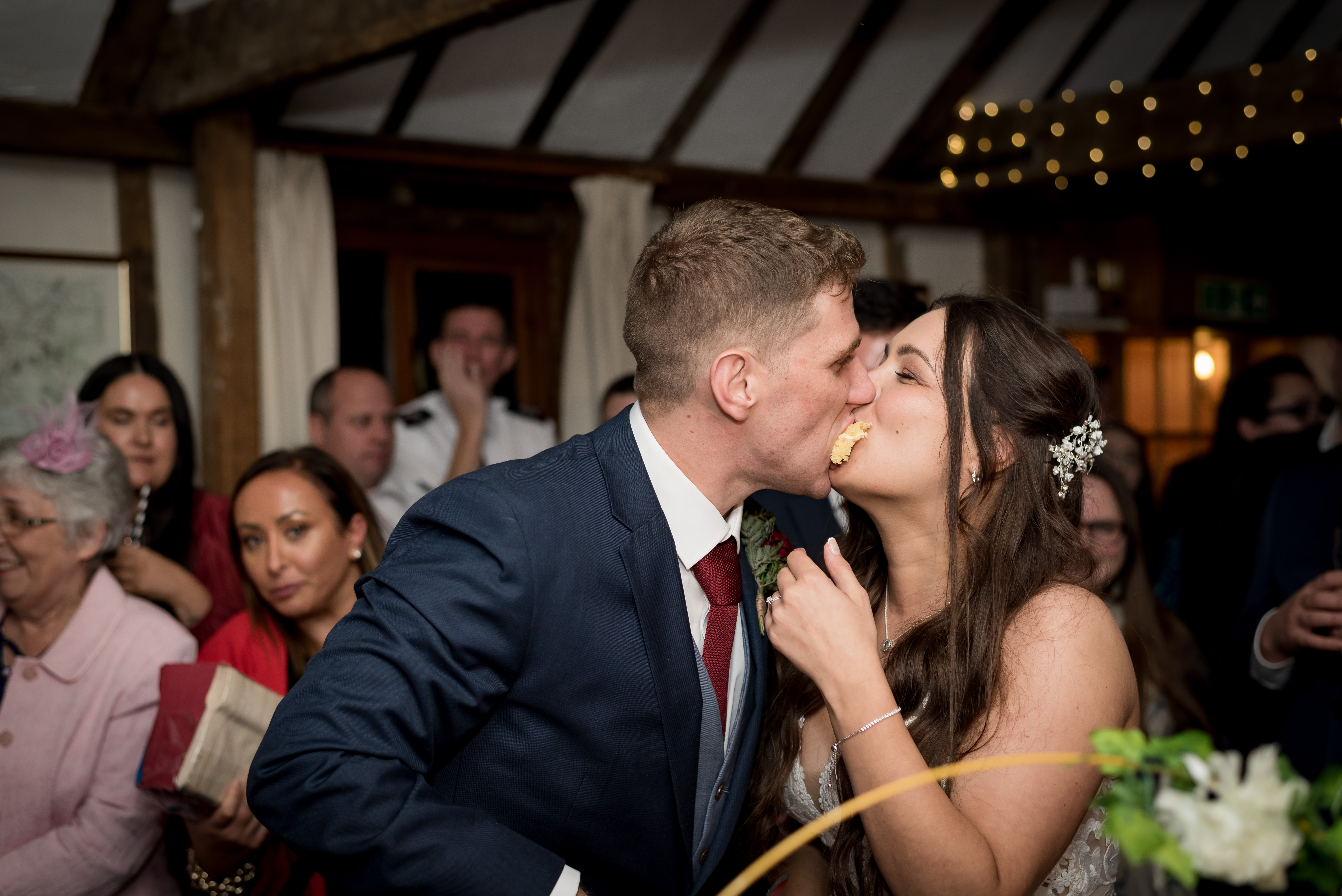 Wedding couple kiss while eating wedding cake