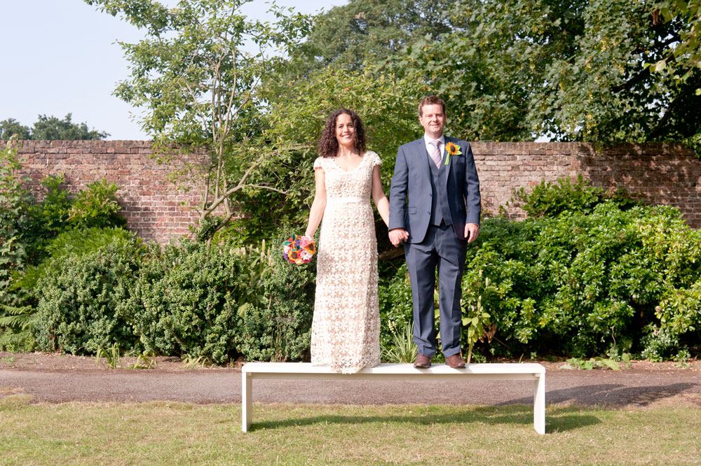 Couple holding hands whilst stood on bench