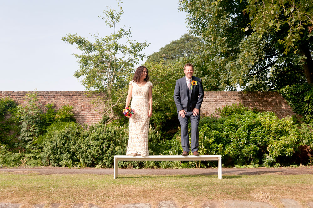 Couple laughing whilst stood on bench