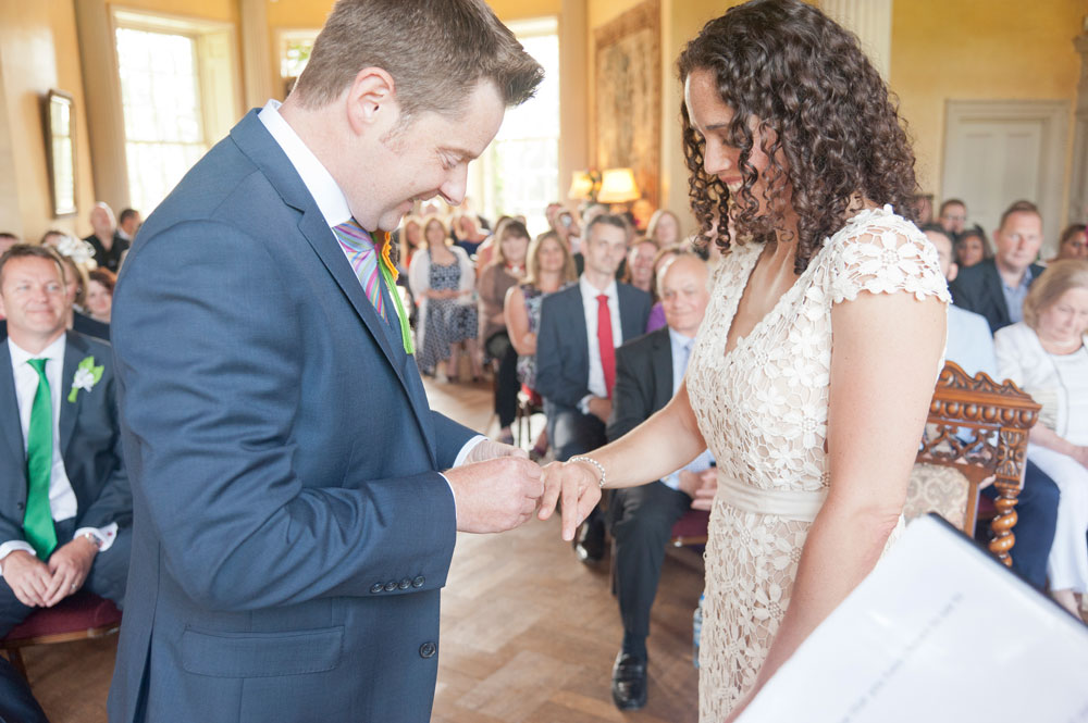 Groom trying to get ring on bride&rsquo;s finger