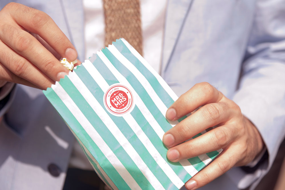 Guest hodling popcorn bag with couple&rsquo;s name on it