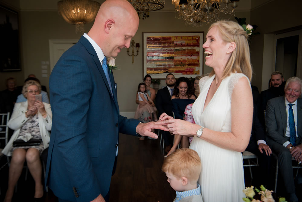 Bride putting ring on groom’s finger