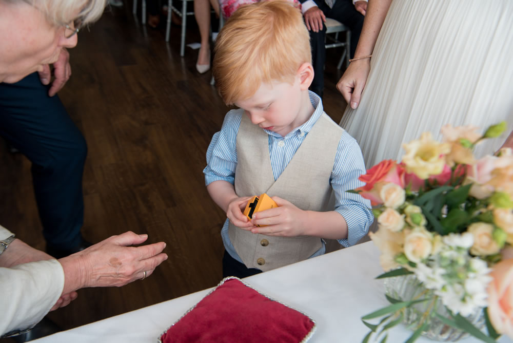 Page boy opening wedding ring box