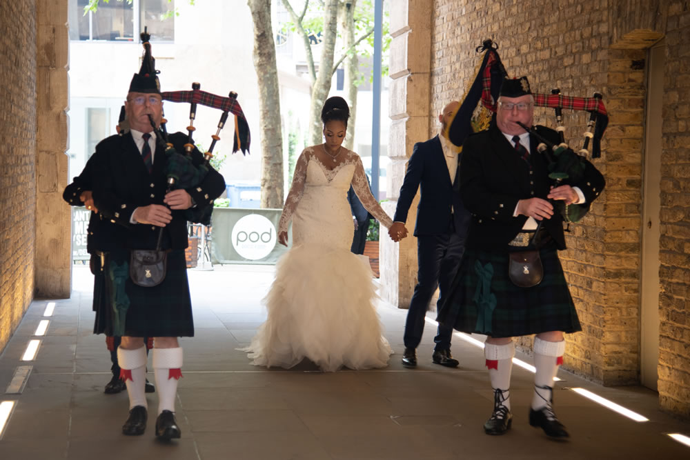 Bagpipers and drummers with couple