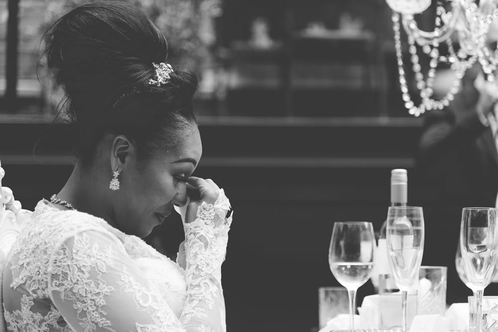 Bride wiping away a tear during groom&rsquo;s speech