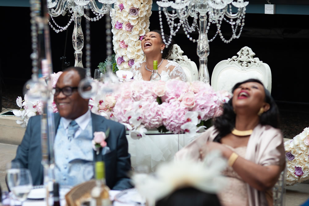Bride and parents laughing during groom&rsquo;s speech