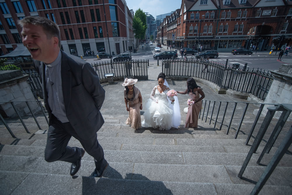 Bride and wedding party walking up the steps of the church