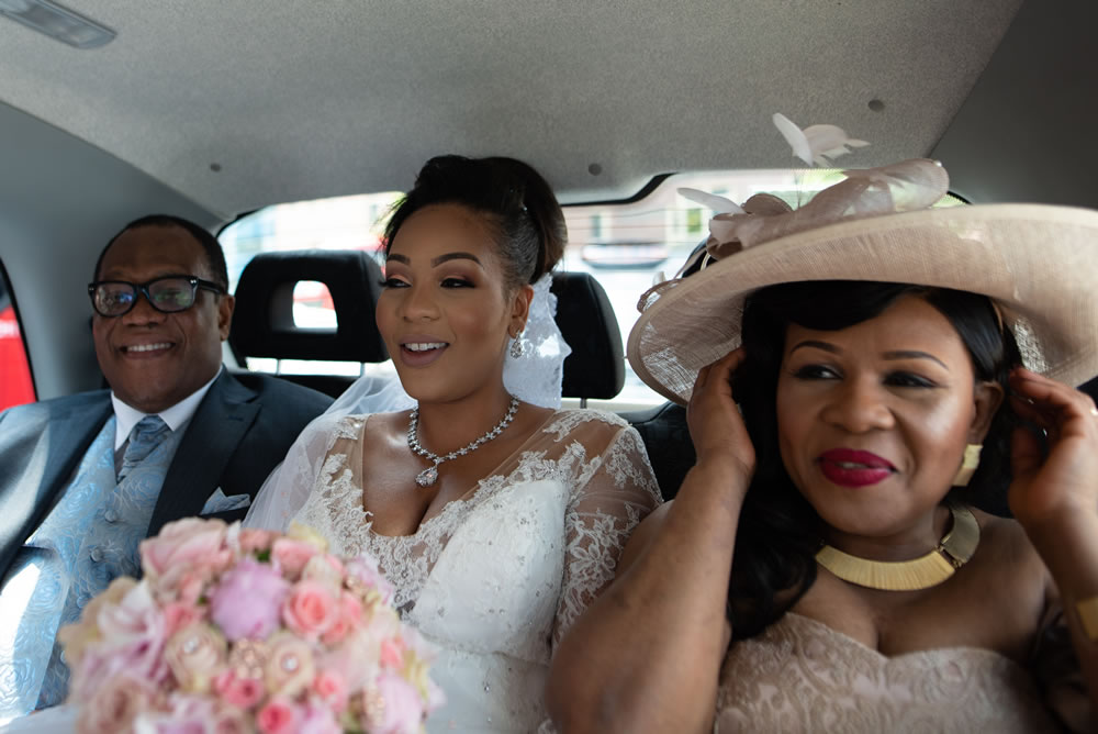 Bride with her parents in the back of a black taxi