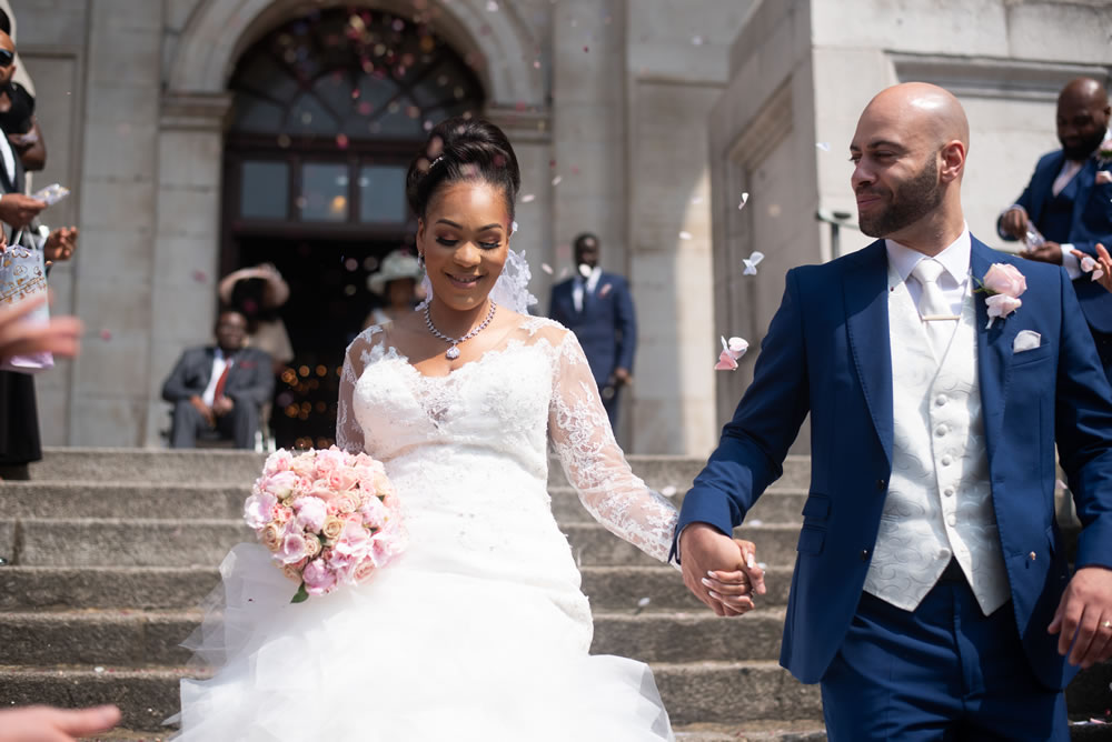 Confetti being thrown at couple on the steps of the church