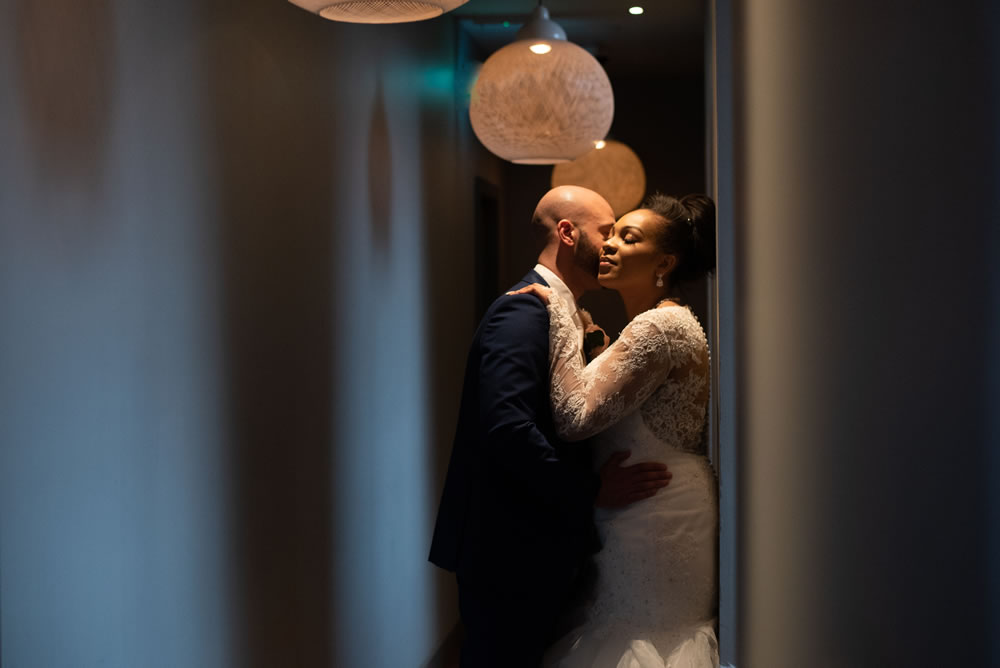 Couple hugging in hallway under lights
