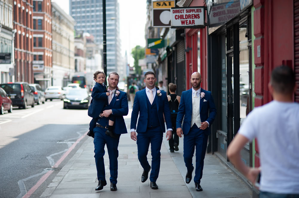 Groom and wedding party walking down the road