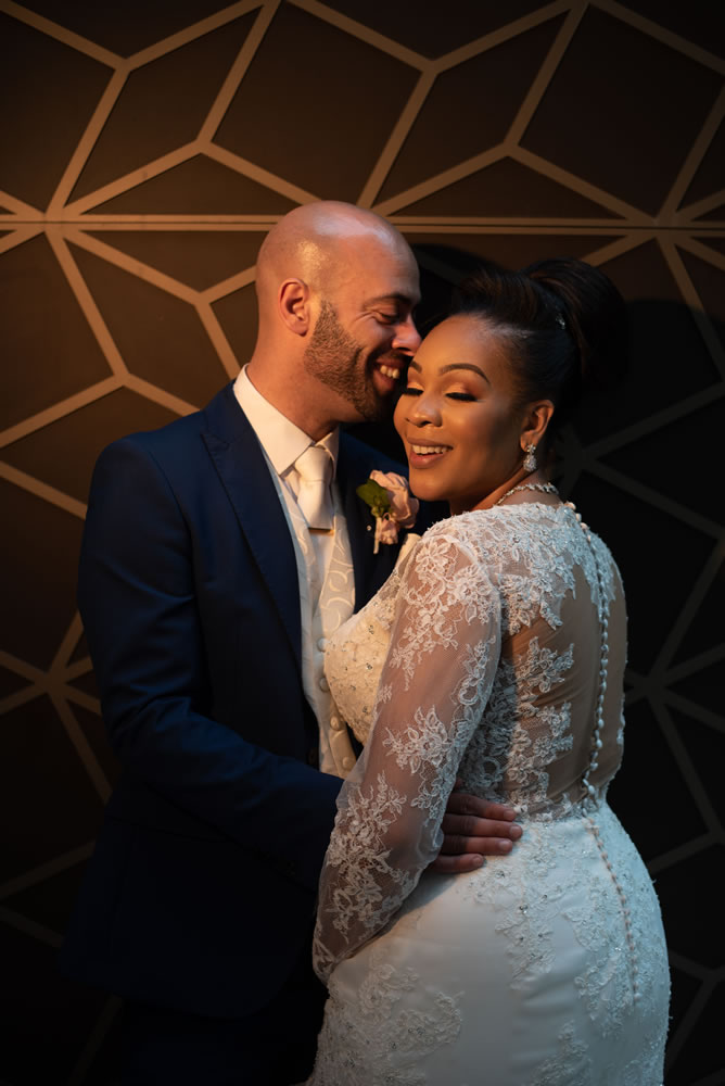 Couple laughing while leaning against wall