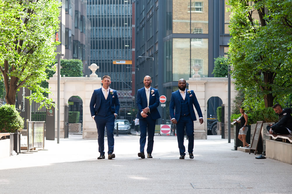 Groom with groomsmen walking towards the camera