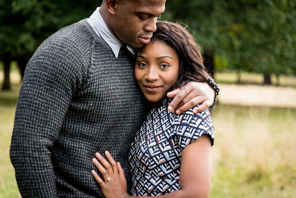 Groom hugging bride while she looks at the camera