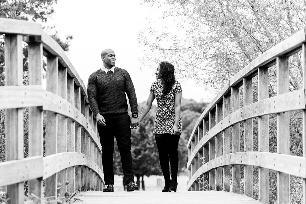 Couple walking over bridge in park