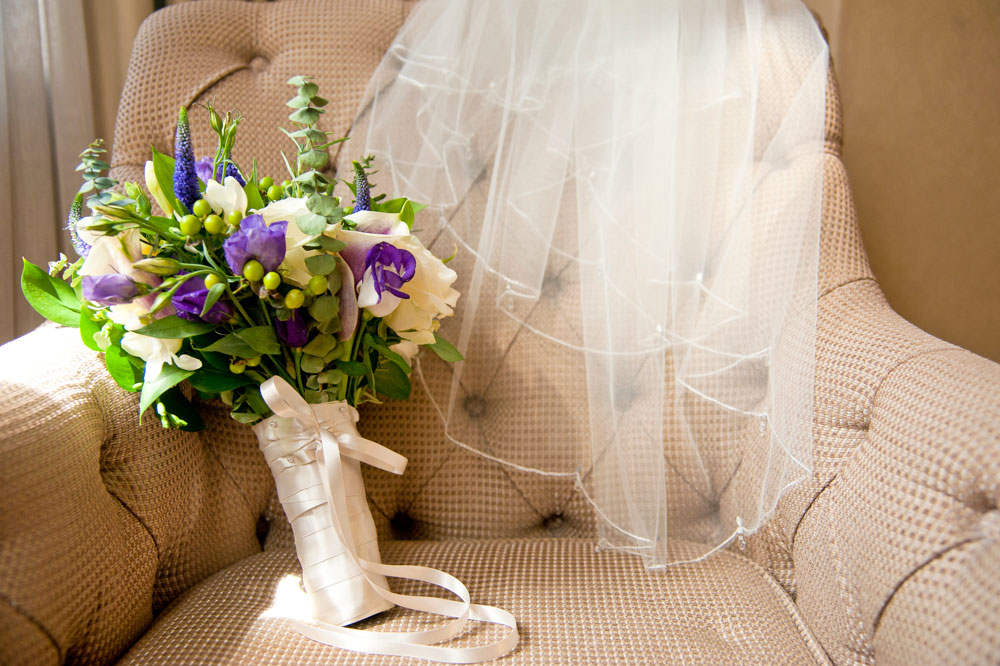 Bride&rsquo;s veil and bouquet on chair