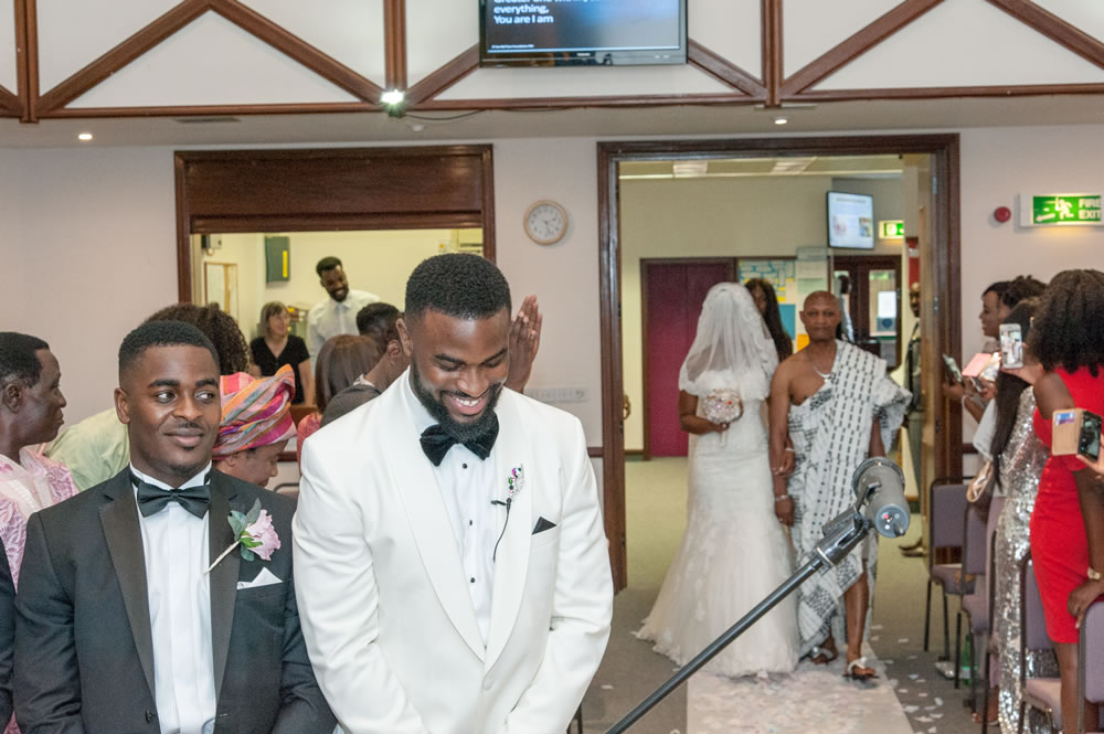 Groom smiling while waiting for bride at the altar