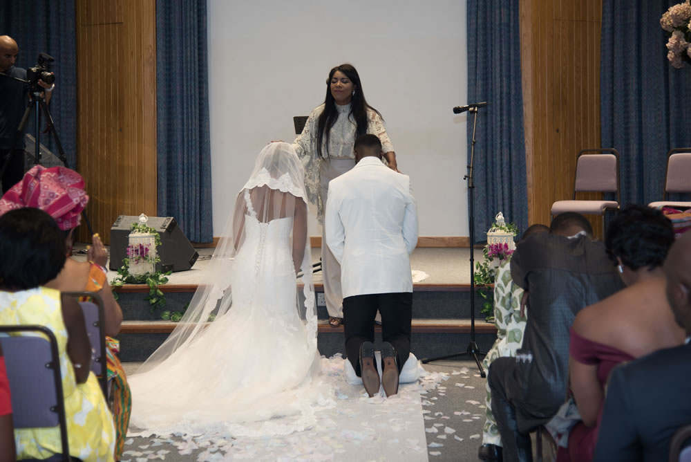 Pastor blessing couple during wedding ceremony