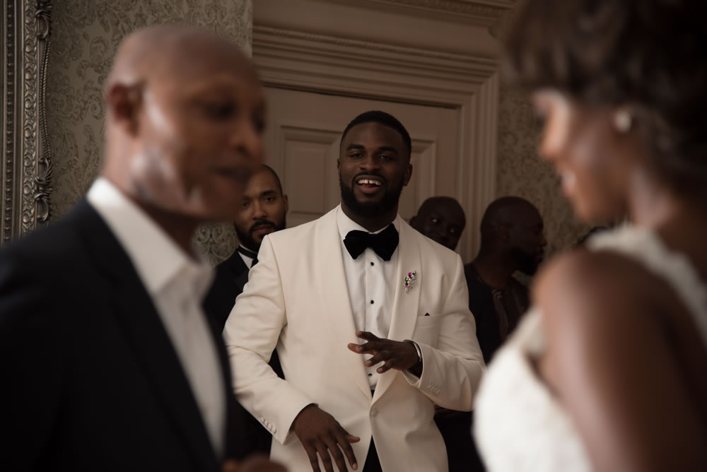 Groom watching father and daughter dance