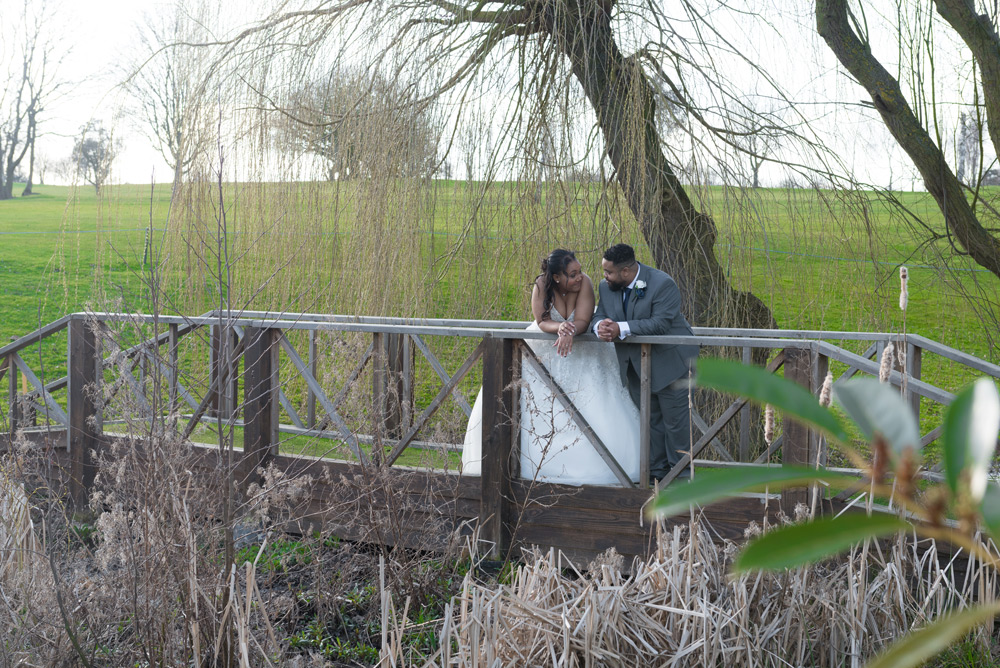 Couple talking leaning over bridge